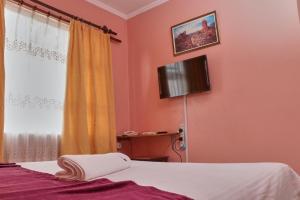 a bedroom with a bed and a tv on the wall at 136 Boutique Address Hotel in Nairobi