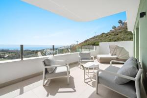 a balcony with chairs and a couch and a table at Chic and stunning views on amazing terrace RDR484 in Mijas Costa
