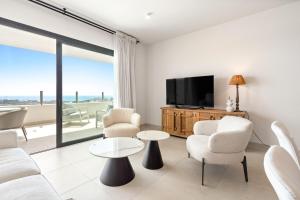 a living room with a couch and chairs and a tv at Chic and stunning views on amazing terrace RDR484 in Mijas Costa