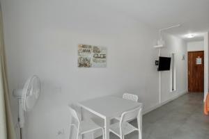 une salle à manger blanche avec une table et des chaises blanches dans l'établissement Estudio Yumbo Playa, à San Bartolomé