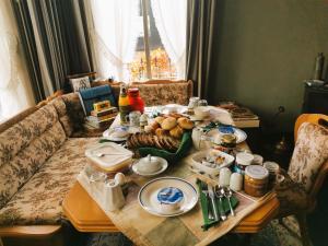 a table with food on it with a couch at B&B Klassiek in Twijzelerheide