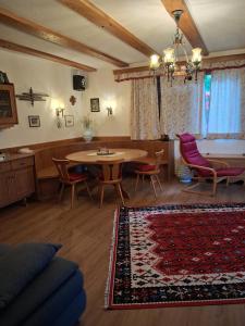 a living room with a table and chairs and a rug at Ferienhaus Hölzl in Trog