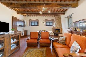 a living room with two orange chairs and a tv at Agriturismo Le Ville in Lano