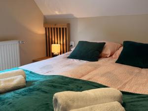 a bedroom with a large bed with two green pillows at Domki Letniskowe Stokrotka in Pustkowo