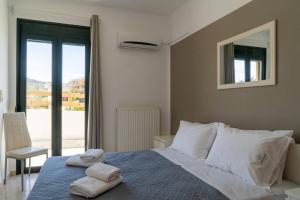 a bedroom with a bed with two towels on it at Three Waves Maisonettes Elena in Análipsis +30 photos