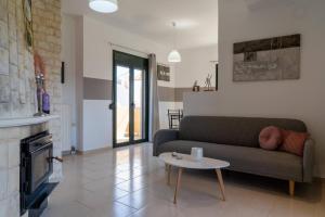a living room with a couch and a table at Three Waves Maisonettes Elena in Análipsis
