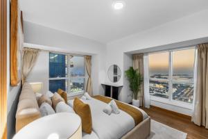 ドバイにあるStylish 2BR in Elite Tower with Bluewaters View and JBRの大きなベッドと大きな窓のある寝室