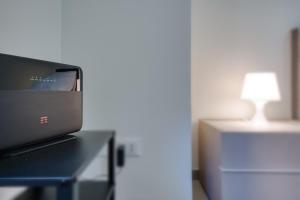 un monitor per computer seduto su una scrivania con una lampada di Calimaruzza Boutique Apartment a Firenze