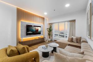 ドバイにあるStylish 2BR in Elite Tower with Bluewaters View and JBRのソファとテレビのあるリビングルーム