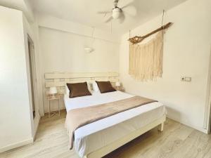 a white bedroom with a large bed in it at Apartamentos Formentera Copacabana 18 in Es Pujols