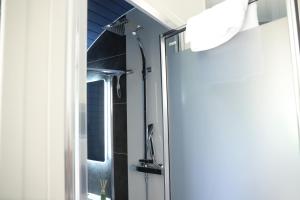 a shower in a bathroom with a mirror at Glamping Retreats in Norwich