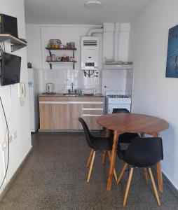 une petite cuisine avec une table et des chaises en bois dans l'établissement La Estrella - alojamiento temporario, à La Plata