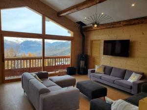 La Plagne TarentaiseにあるChalet Face Nord Cyreliaのソファと薄型テレビのあるリビングルーム