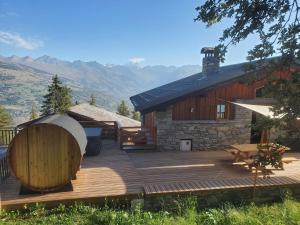 La Plagne TarentaiseにあるChalet Face Nord Cyreliaのログキャビン前の木製デッキ
