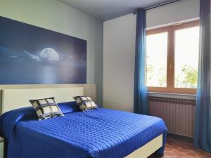 a bedroom with a bed with blue sheets and a window at IseoLakeRental - Villa Luna in Riva di Solto