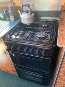 a stove with a tea pot on top of it at Stone - Boat - Sleeps 4 - Pet Friendly-85ws in Stone