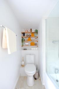 a bathroom with a toilet and a bath tub at Beautiful 3BD Thatched Stone Cottage Kettering in Pytchley