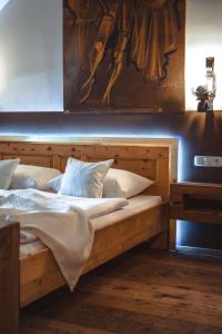 a bedroom with two beds and a painting on the wall at Apartmenthaus Gasthof Burg Heimfels in Heinfels