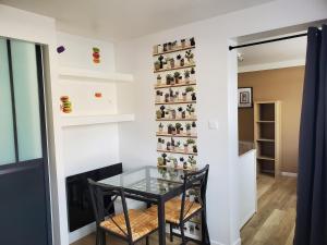 a glass table in a room with a wall of figurines at Bastille 5 in Saintes