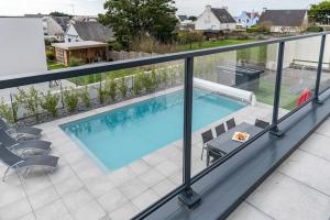 balkon z widokiem na basen w obiekcie Villa avec piscine, vue mer, 200 m de la plage w mieście Clohars-Carnoët