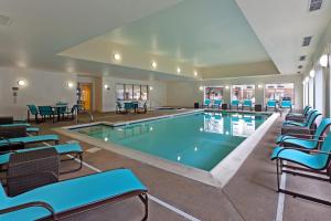 a swimming pool with blue chairs and tables at Residence Inn Indianapolis Carmel in Carmel