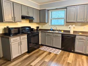 a kitchen with gray cabinets and black appliances at Private Cul-de-Sac Oasis 4BR in Grove City