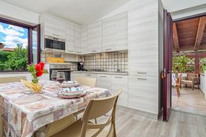 a kitchen with a table with a vase of flowers on it at Orsa Maggiore Ottiolu in Porto Ottiolu