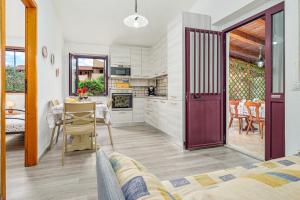 a kitchen and living room with a door leading to a dining room at Orsa Maggiore Ottiolu in Porto Ottiolu