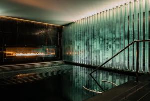 a swimming pool with a fireplace in a building at Corinthia London in London