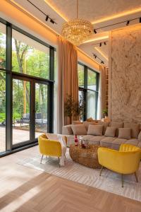 a living room with a couch and yellow chairs at LUXURY LOFT with LOVE SEASIDE self check-in in Klaipėda