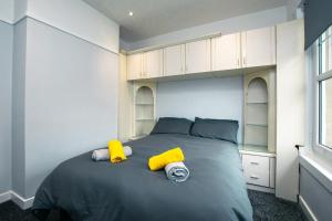 a bedroom with a large black bed with yellow pillows at Cosy & Central 2BD Apartment Milngavie, Glasgow in Milngavie