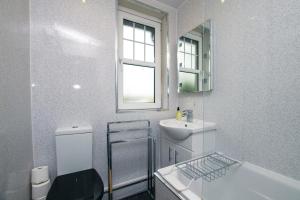 a bathroom with a sink and a toilet and a mirror at Cosy & Central 2BD Apartment Milngavie, Glasgow in Milngavie +31 photos