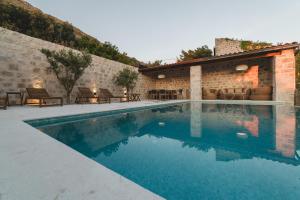 a swimming pool with tables and chairs next to a building at Villa Boscovich in Katun