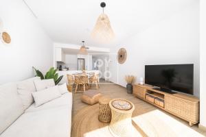 un soggiorno con un divano bianco e una televisione di Boho Breeze Penthouse - By Oyoostays a Pilar de la Horadada