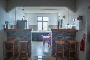 a kitchen with a table and some stools in it at Ermitage Holiday Home in Rodrigues Island