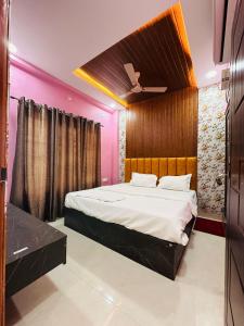 a bedroom with a large bed with pink walls at Hotel Airport Suites Suitable for Hourly Bookings in Lucknow