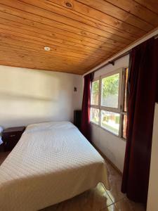 a bedroom with a bed and a window at Apart Los lirios in La Porteña