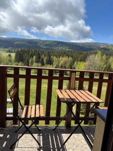 - une table de pique-nique en bois et une chaise sur le balcon dans l'établissement Doboszowka, à Lasowka