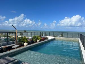 a swimming pool with a view of the ocean at Flat GRÉCIA na praia do Bessa, João Pessoa, Paraíba in João Pessoa