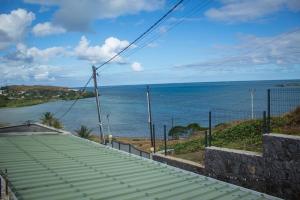 a view of the ocean from the balcony of a house at Ermitage Holiday Home in Rodrigues Island