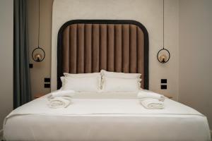 a bed with white sheets and pillows in a room at Diamar Suites in Durrës
