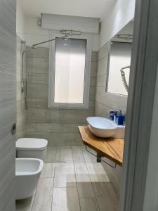 a bathroom with two sinks and a toilet at Wave House in Montesilvano +13 photos