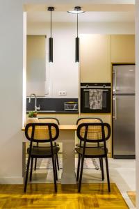 a kitchen with two chairs at a counter with a refrigerator at Attica Skyline Living! in Athens +39 photos