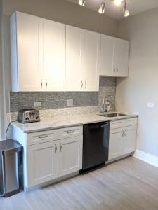 a kitchen with white cabinets and a sink at Spacious Bronzeville Apartment in Chicago