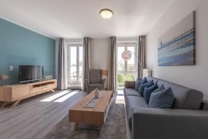 a living room with a couch and a tv at Ferienwohnung Ostseesonne mit Balkon - direkt an der Ostsee gelegen in Zingst