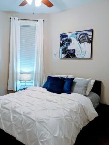 a bedroom with a white bed with a ceiling fan at Spacious Bronzeville Apartment in Chicago