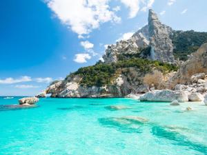 a beach with blue water and a mountain at Osulai 18 in Santa Maria Navarrese