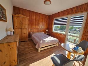 a bedroom with a bed and a large window at Pokoje gościnne in Międzyzdroje