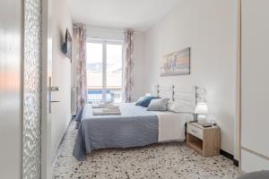 ein weißes Schlafzimmer mit einem Bett und einem Fenster in der Unterkunft H11 AI CASTELLETTI Mare - Parcheggio in Arma di Taggia + 19 Fotos