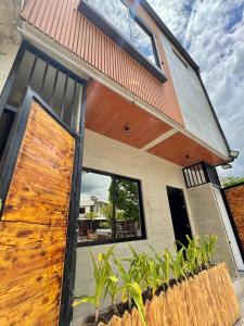 ein Haus mit einer Holztür und einem Zaun in der Unterkunft K-Ville - Loft House Near Philippine Arena in Sampong